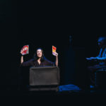 Melania Cruz saca folletos da maleta e Vadim Yukhnevich toca o piano nunha escena de 'Continente María'